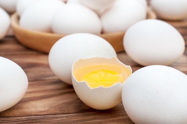 Oeuf cassé et bol avec des oeufs entiers sur la table Gros plan