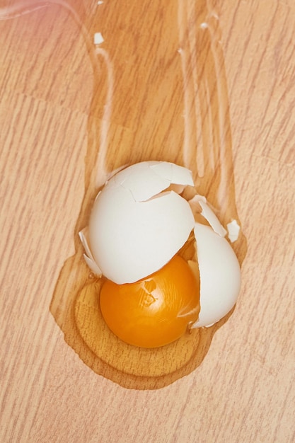 Oeuf cassé sur le plancher en bois