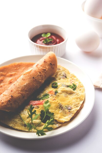 Photo oeuf chapati - omelette roll ou franky. recette indienne populaire, rapide et saine pour le tiffin ou la boîte à lunch des enfants. servi sur fond de mauvaise humeur. mise au point sélective