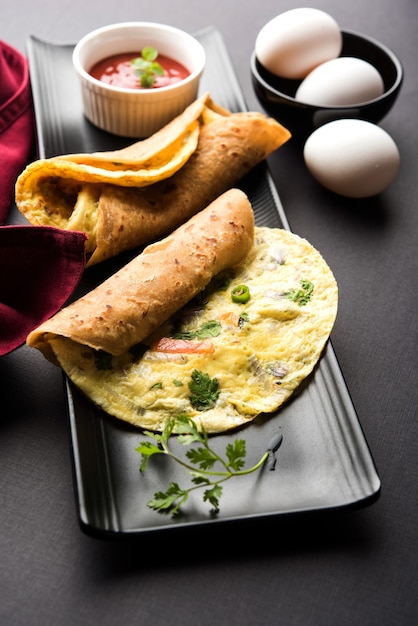 Photo oeuf chapati - omelette roll ou franky. recette indienne populaire, rapide et saine pour le tiffin ou la boîte à lunch des enfants. servi sur fond de mauvaise humeur. mise au point sélective