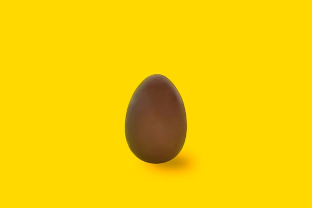 Oeuf en chocolat sur fond jaune