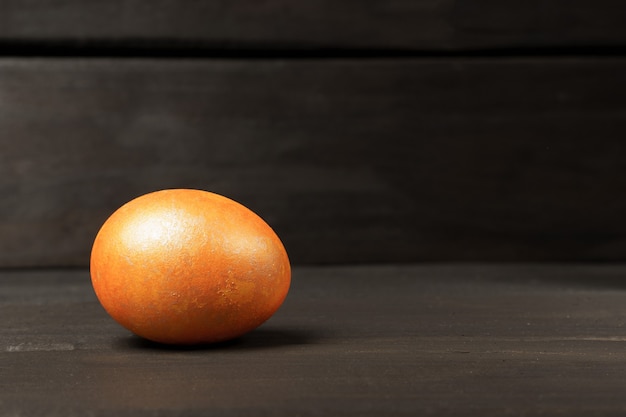 Oeuf coloré sur une table sombre