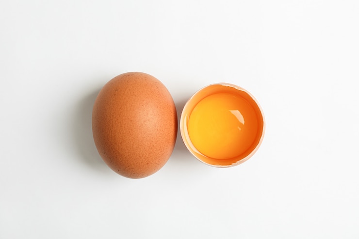 Photo œuf entier et demi-œuf au jaune sur blanc