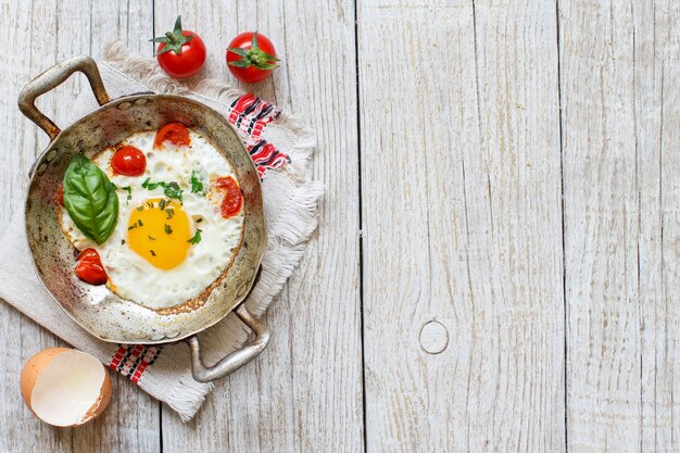 Œuf Frit Aux Tomates Et Herbes Dans Une Vieille Poêle à Frire Sur Bois