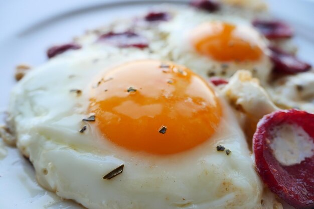 Oeuf frit mélangé avec de la saucisse sur une assiette