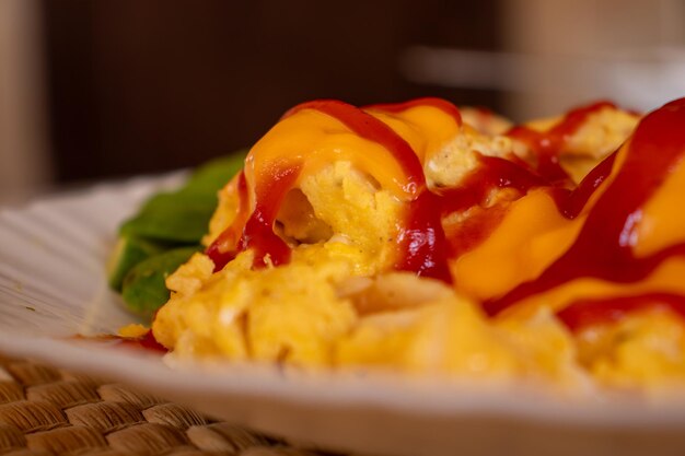 Oeuf et fromage avec du ketchup et à côté de l'avocat