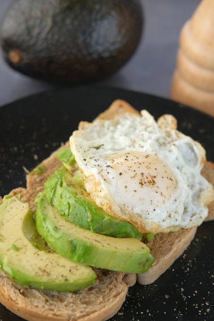 Oeuf de pain brun à l'avocat et romarin sur table