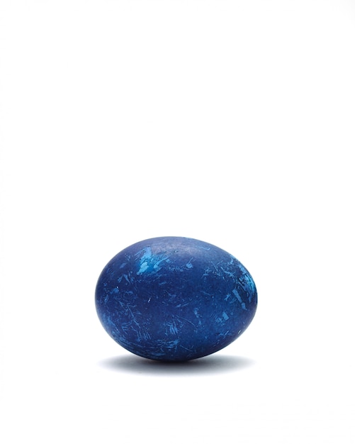 Oeuf de Pâques bleu décoré sur fond blanc