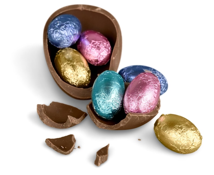 Photo oeuf de pâques en chocolat cassé avec des bonbons colorés sur fond blanc