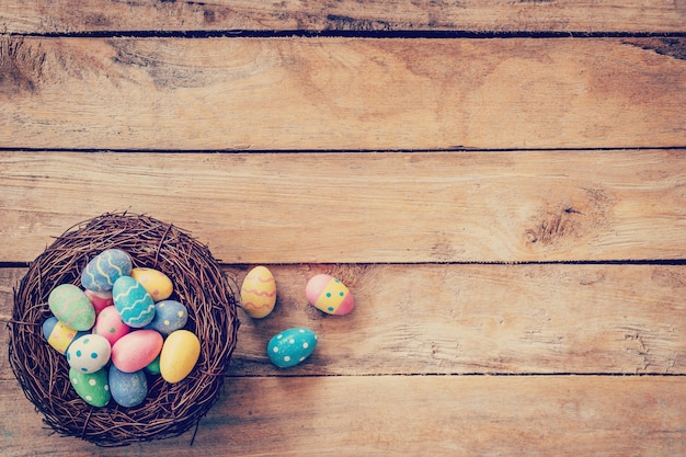 Oeuf de pâques coloré dans le nid sur fond en bois avec de l&#39;espace