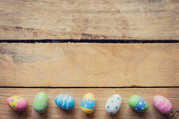 Oeuf de Pâques coloré sur fond de bois avec espace.