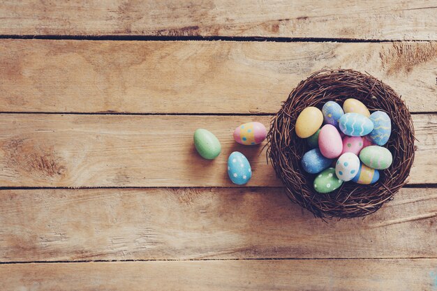 Oeuf de Pâques coloré et nid sur fond de table en bois avec espace de copie.