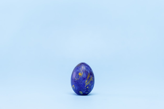 Un œuf de pâques couleur tendance bleu classique et doré sur bleu