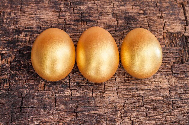 Oeuf de Pâques doré sur planche de bois brute marron