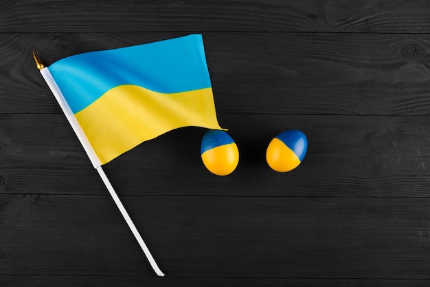 Oeuf de pâques avec le drapeau de l'ukraine sur un fond en bois