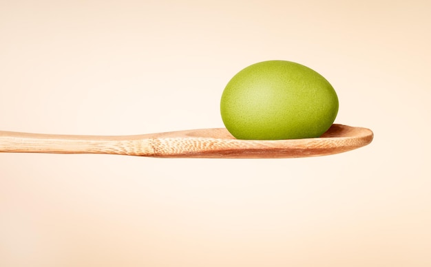 Oeuf de pâques teint en vert dans une cuillère en bois fête religieuse célébration cuisine et peinture tradition p