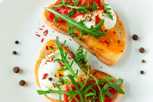 oeuf poché sur pain blanc avec tomates mozzarella et roquette