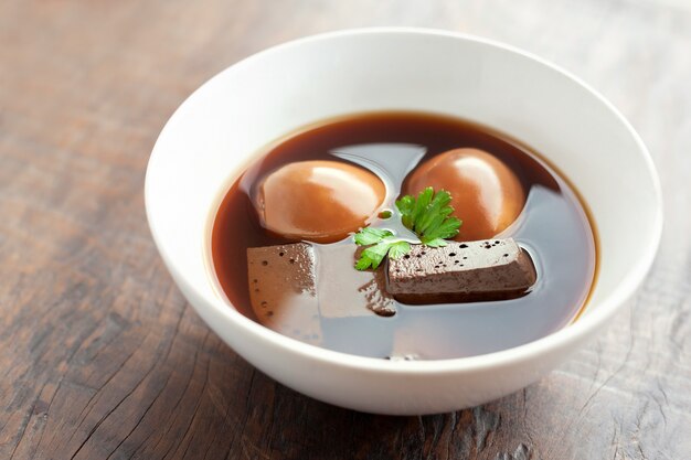 Oeuf et porc en sauce brune douce sur une table en bois, cuisine thaïlandaise.