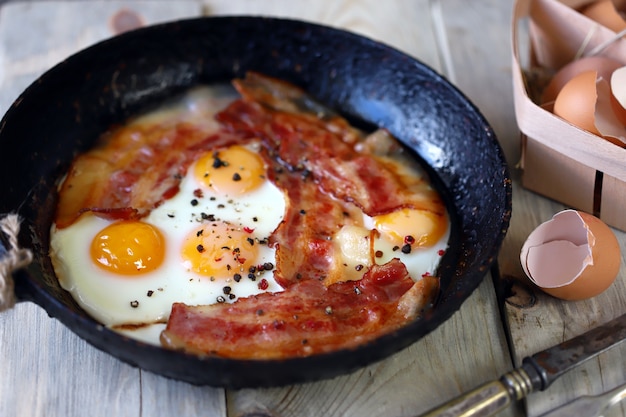 Oeufs au bacon dans une poêle à frire Style rustique