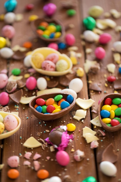des œufs au chocolat et des gouttes de bonbons sur une table en bois