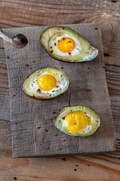 Oeufs au four à l'avocat sur fond rustique