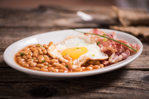 Oeufs au plat avec bacon bio, pommes de terre rissolées et toasts croustillants