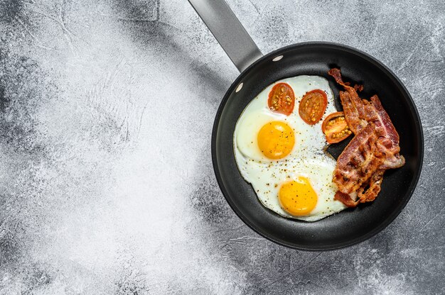 Oeufs au plat avec bacon dans une casserole.