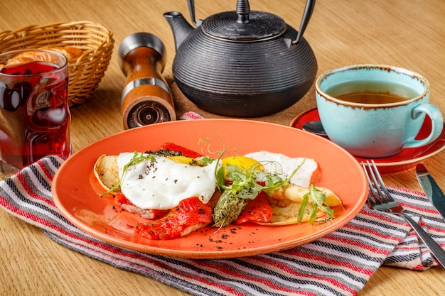 Oeufs au plat et crêpes sur une plaque