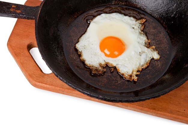 Oeufs au plat sur une poêle à frire sur une planche