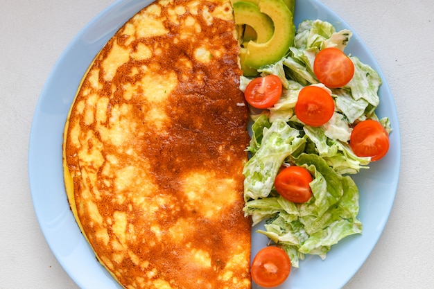 Oeufs au plat avec salade de légumes. Omelette avec salade de légumes.