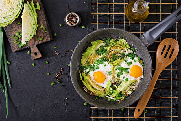 Oeufs au plat avec des tranches de jeune chou et verts. Petit déjeuner nutritif. Vue de dessus. Mise à plat