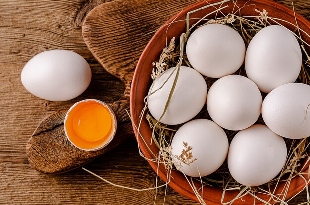 Oeufs blancs biologiques crus sur table en bois. Vue de dessus