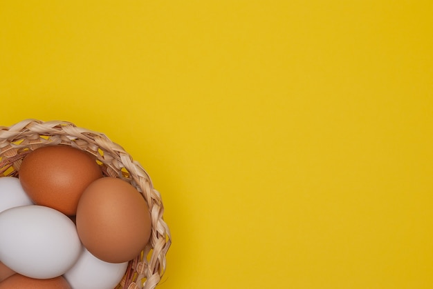 Oeufs blancs et bruns dans le panier avec espace de copie