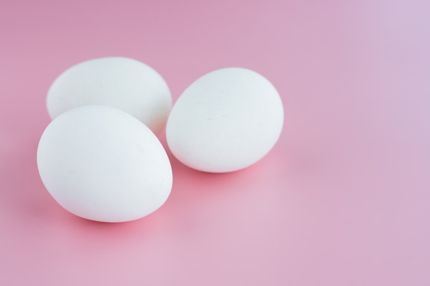 Oeufs blancs sur fond rose pour la cuisson des aliments