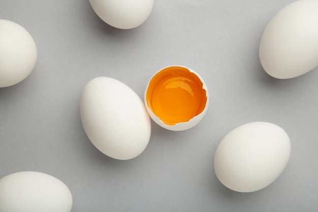 Oeufs blancs et jaune d'oeuf sur le mur gris. Concept de Pâques