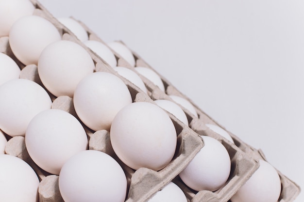 Oeufs blancs d'une poule dans un emballage en carton inoffensif