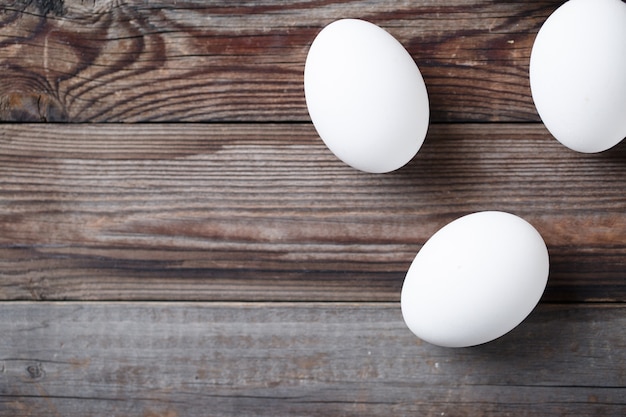 Oeufs blancs sur la vieille table en bois