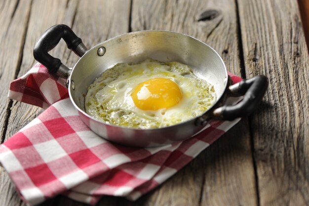 Oeufs brouillés dans une poêle en fer sur la table en bois rustique