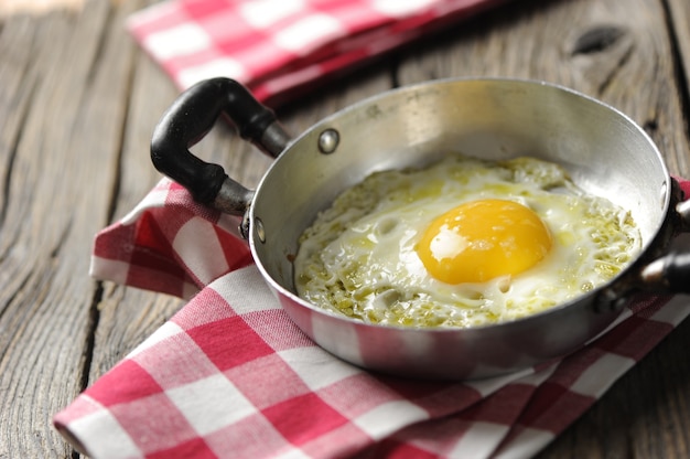 Oeufs brouillés dans une poêle en fer sur la table en bois rustique