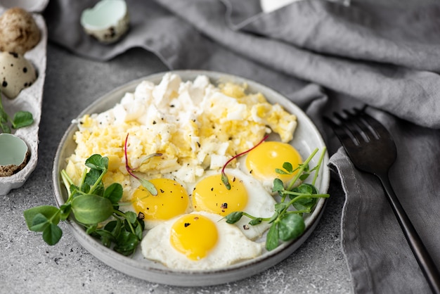 Oeufs brouillés et omelette aux œufs de caille sur une plaque grise