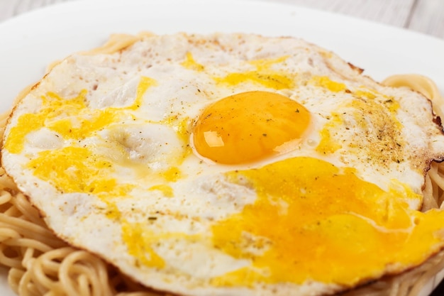 Oeufs brouillés avec des pâtes sur une assiette