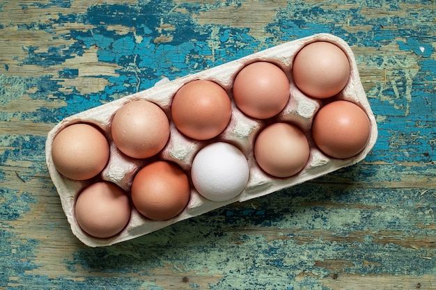 Oeufs bruns dans un plateau séparé sur table en bois vintage