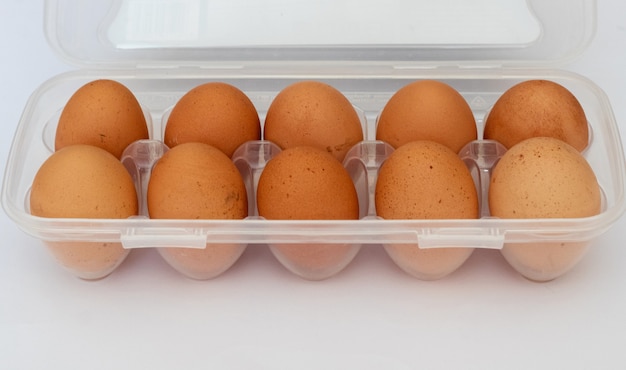 Oeufs bruns rustiques dans un sac en plastique Emballage d'oeufs sur fond blanc