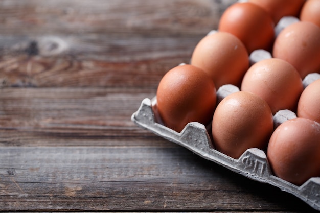 Oeufs bruns sur une table en bois rustique.