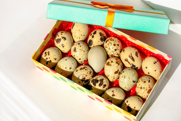 Oeufs de caille dans une boîte en carton sous les rayons du soleil.