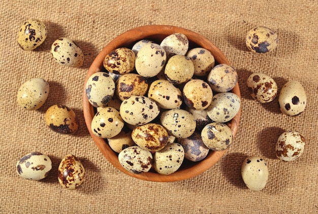 Oeufs de caille dans un bol en bois dans un fond de sac