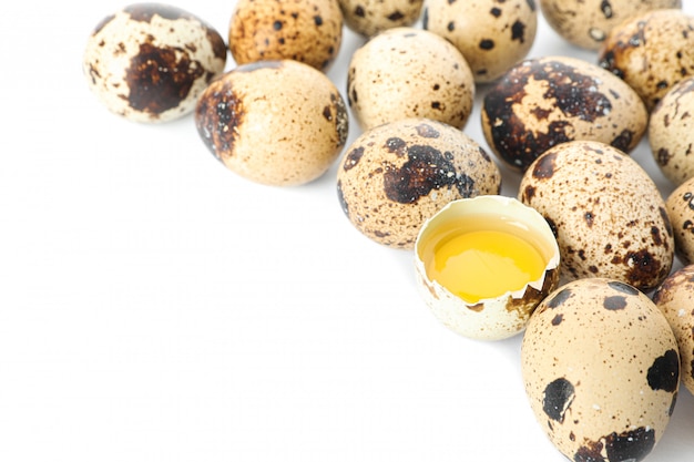 Oeufs de caille et demi-oeuf cassé avec jaune isolé sur blanc