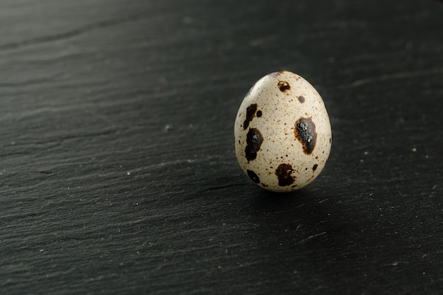 Oeufs de caille sur fond de pierre noire. Produit biologique.