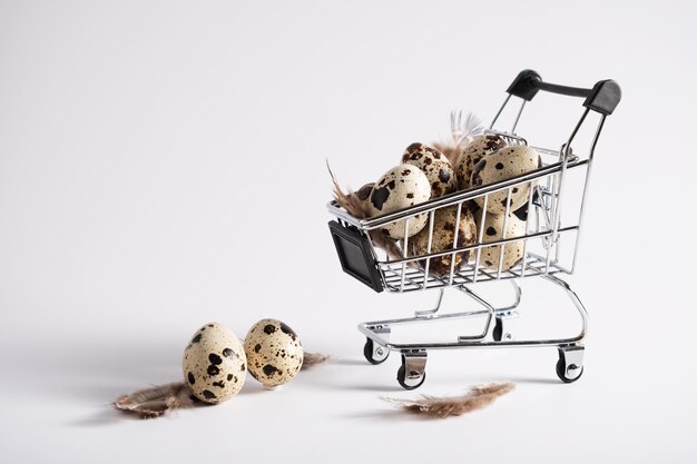 Oeufs de caille frais dans un panier alimentaire sur fond blanc