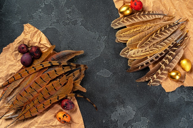 Oeufs de caille de Pâques en plumes sur fond sombre